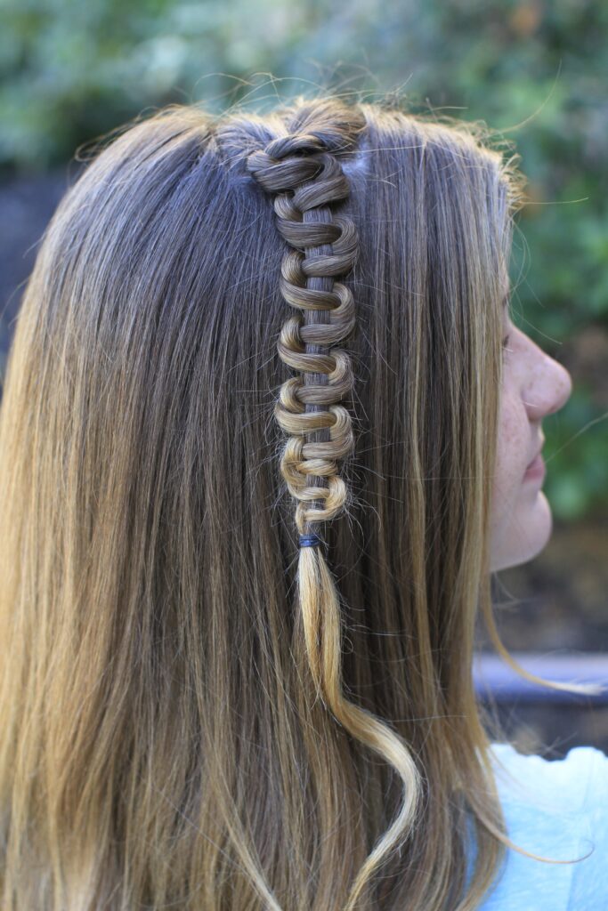 Side view of young girl modeling "Teen Slide-Up Braid" hairstyle outside