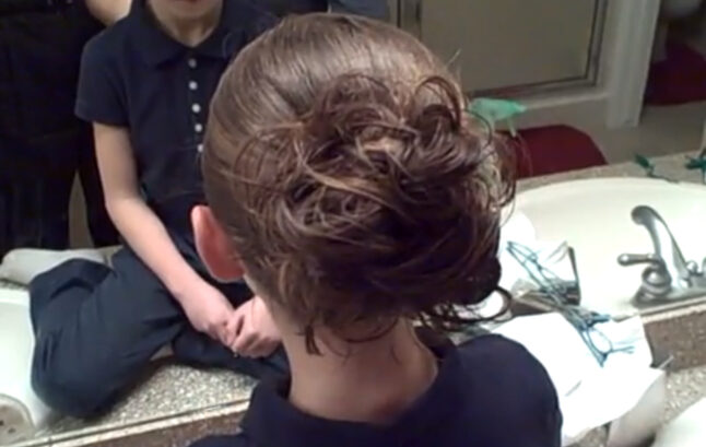 Back view of young girl modeling "Messy Bun" hairstyle