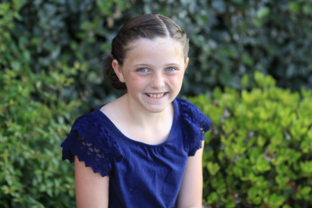 Portrait view of young girl modeling Twistbacks into Side Ponytail