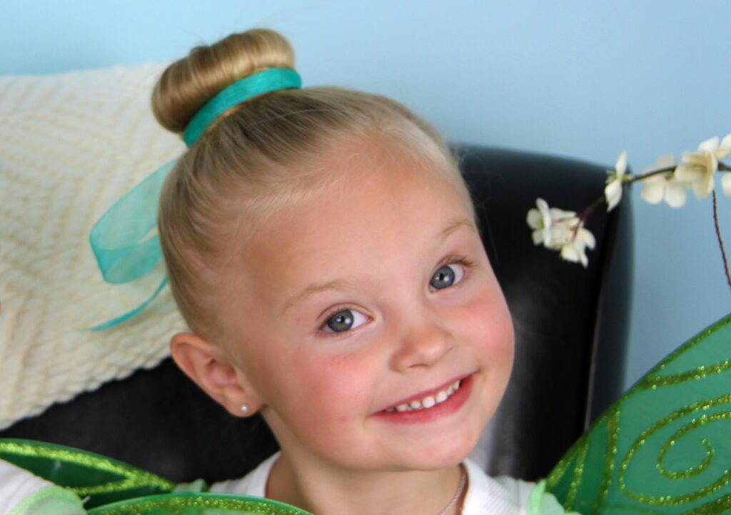 Portrait of a little girl modeling Tinker Bell Hair Bun | Disney Hairstyles