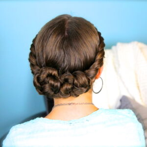 Back view of young girl wearing a blue shirt modeling Double-Twist Bun Updo | Homecoming Hairstyles