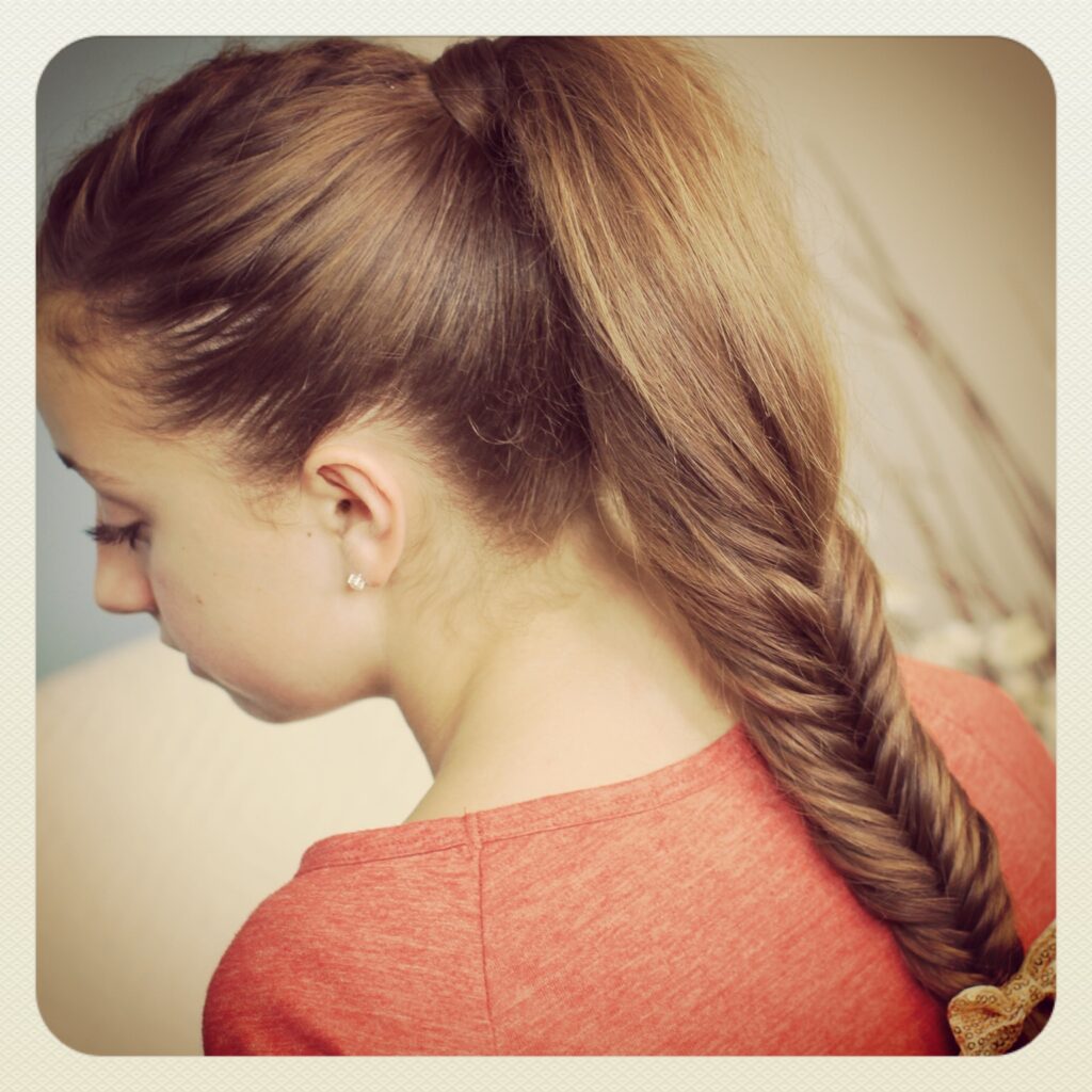 Close-up of young girl wearing a red shirt modeling Fluffy Fishtail Braid | Hairstyles for Long Hair