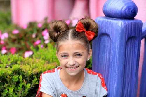 Portrait of a young girl outside modeling Minnie Mouse Buns Hairstyle Tutor...