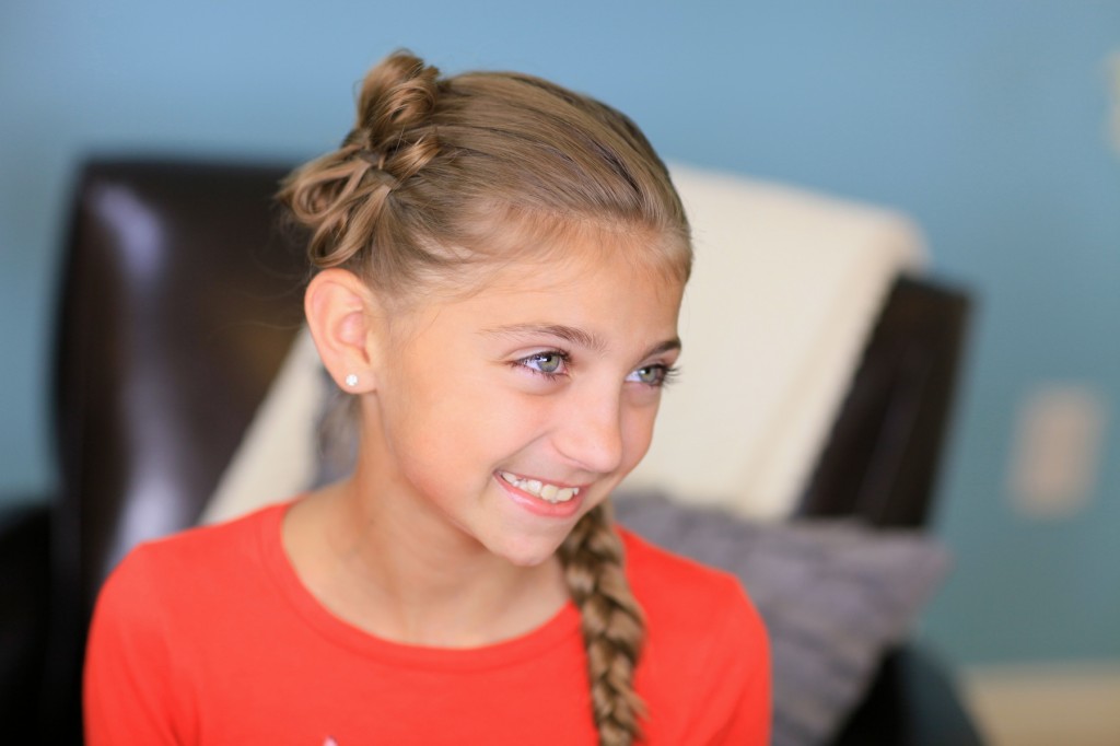 Portrait of young girl wearing a red shirt indoors modeling Diagonal Bow Braid | Popular Hairstyles