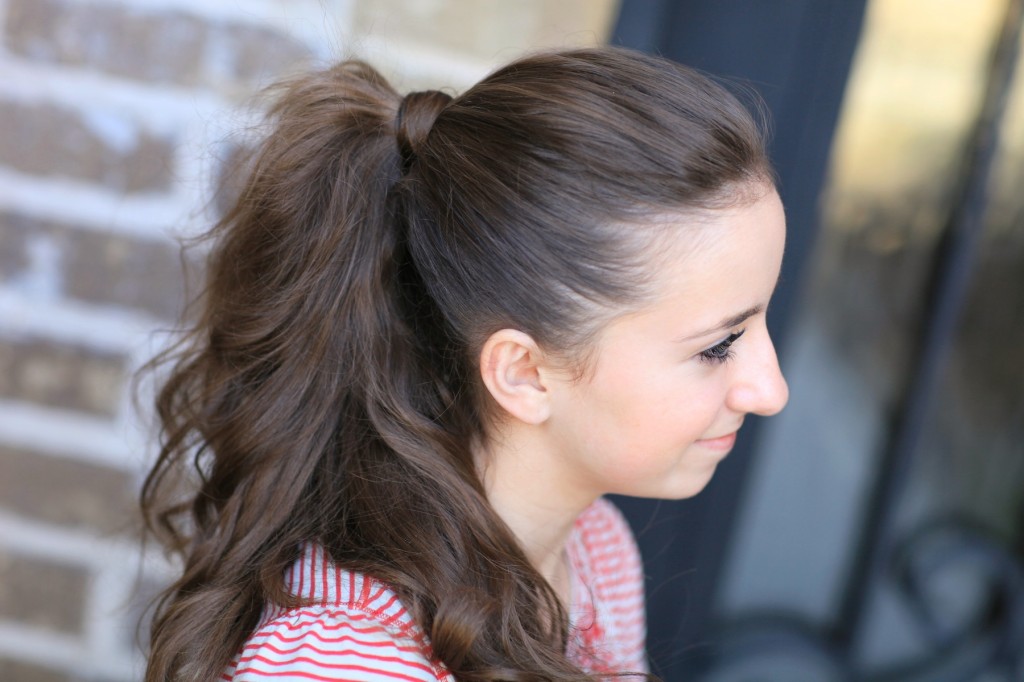 Young girl outside modeling a red shirt modeling the "perfect ponytail" 