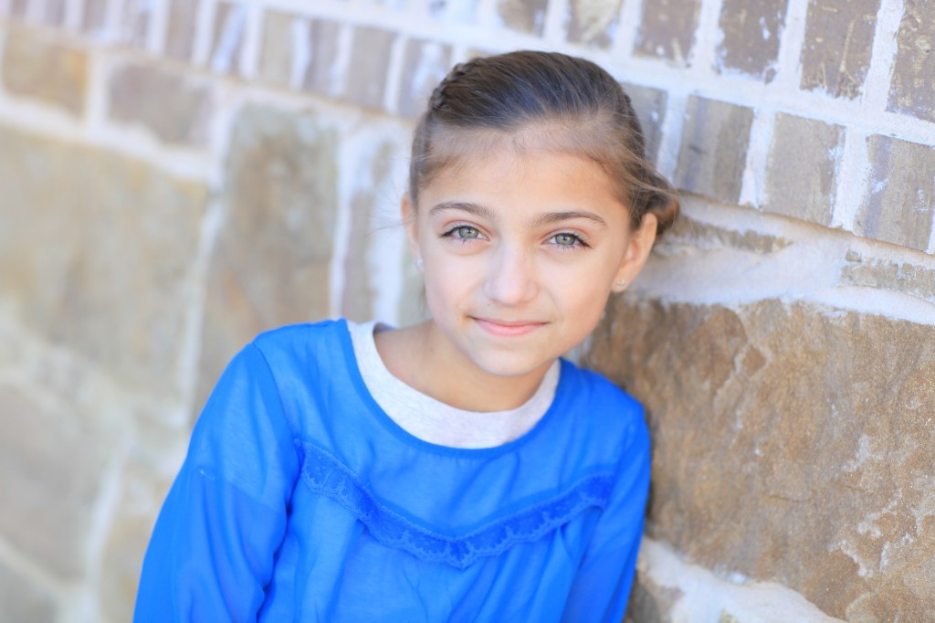 Portrait of a little girl outside in a blue shirt modeling Zipper Braid | Updo Hairstyles