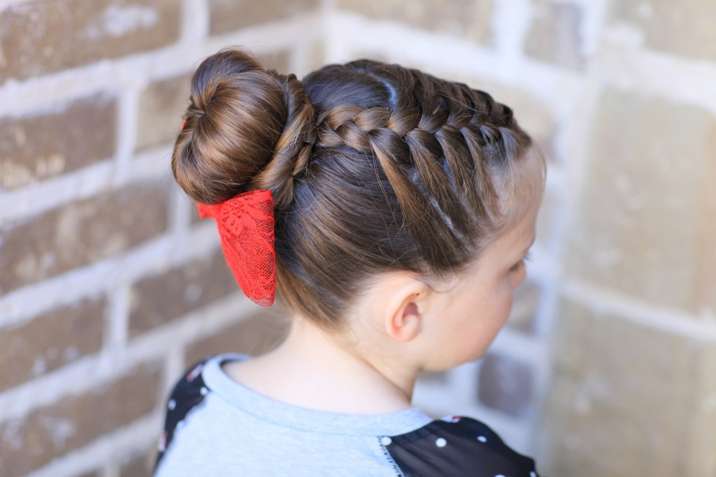 Young girl outside modeling "Love Bun" with a red bow in her hair | Valentine's Day Hairstyles