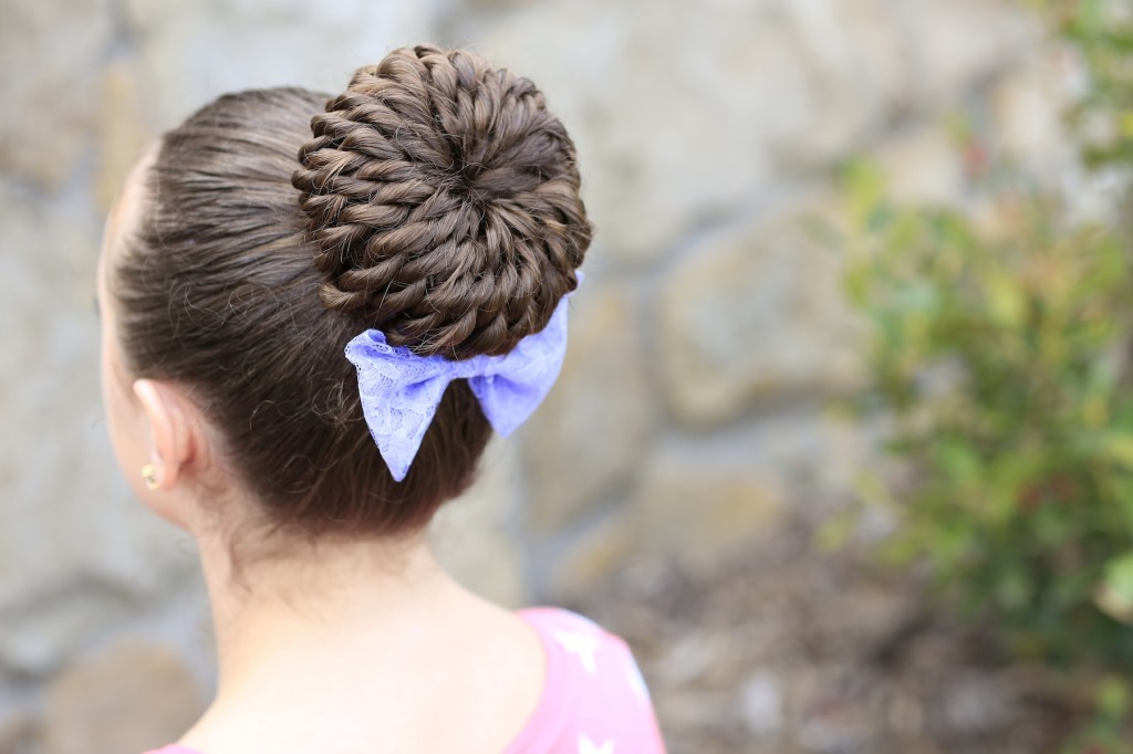 Young girl standing outside modeling Rope Twisted Pinwheel Bun | Prom Hairstyles