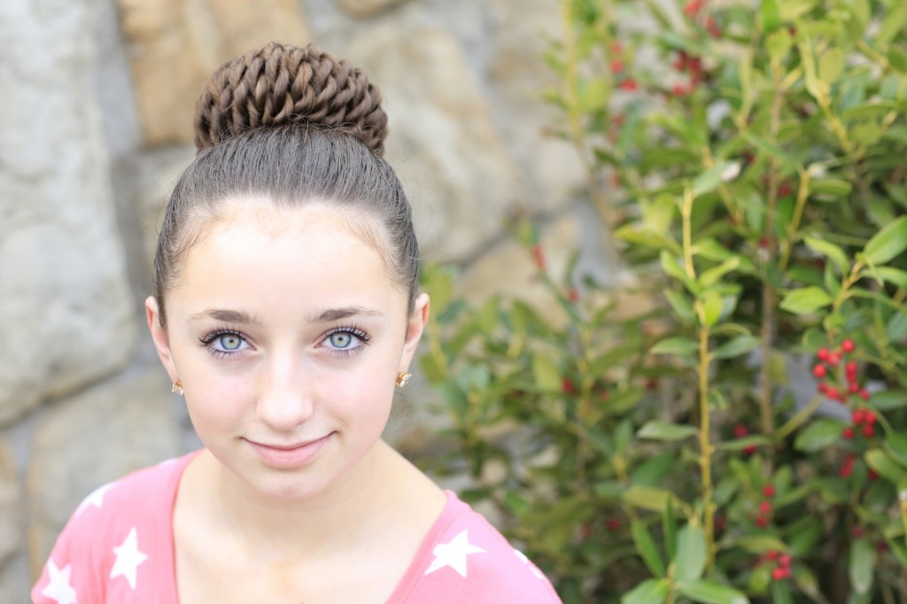 Young girl standing outside modeling Rope Twisted Pinwheel Bun | Prom Hairstyles