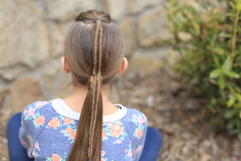 Young girl standing outside modeling Fishtail-Accented Ponytail | Hairstyles for Sports