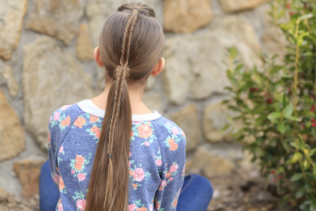 Young girl standing outside modeling Fishtail-Accented Ponytail | Hairstyles for Sports