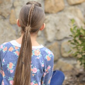 Young girl standing outside modeling Fishtail-Accented Ponytail | Hairstyles for Sports