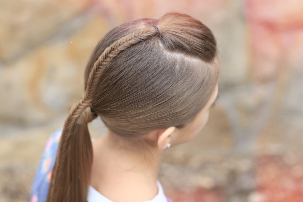 Young girl standing outside modeling Fishtail-Accented Ponytail | Hairstyles for Sports