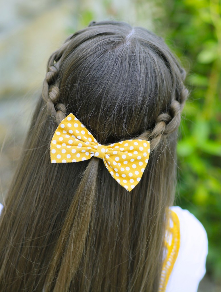 Young girl outside modeling Knotted Braid Tieback