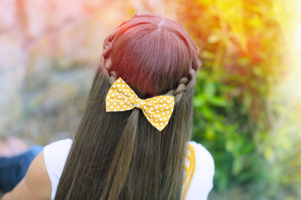 Young girl outside modeling Knotted Braid Tieback
