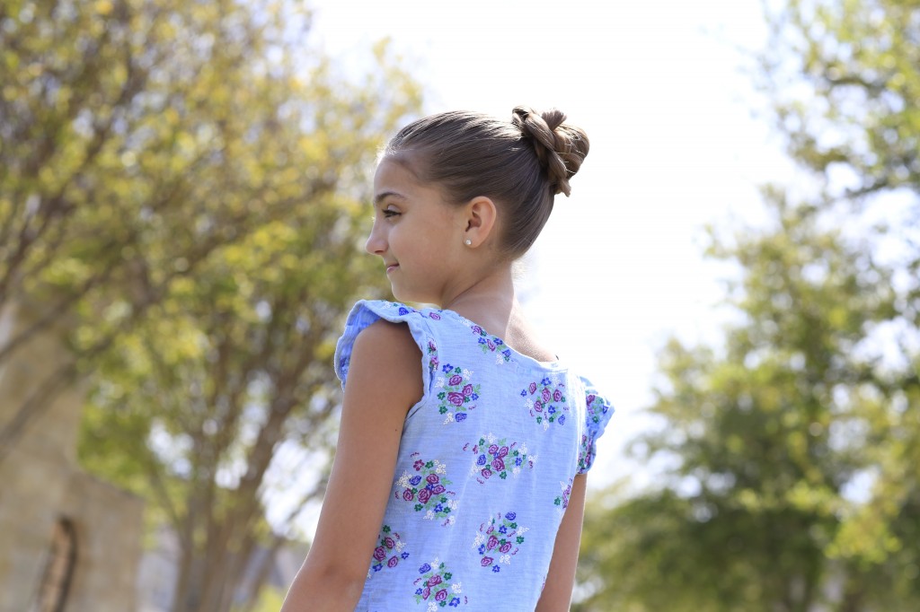 Little girl sitting outside modeling 3D Flower Bun Updo