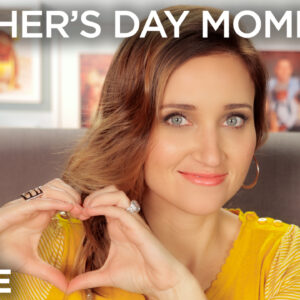 Woman posing while sitting in a chair in the living room making a heart with her palms