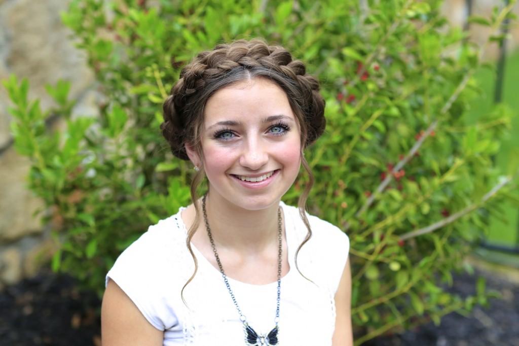 Young girl outside wearing a white shirt modeling Milkmaid Braids | Summer Hairstyles