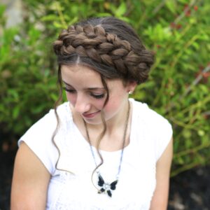 Young girl outside wearing a white shirt modeling Milkmaid Braids | Summer Hairstyles