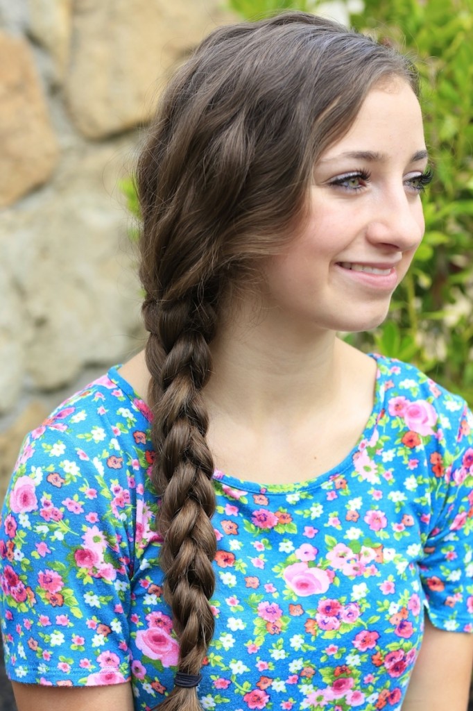 Young girl outside wearing a floral blue shirt modeling 3D Split Braid