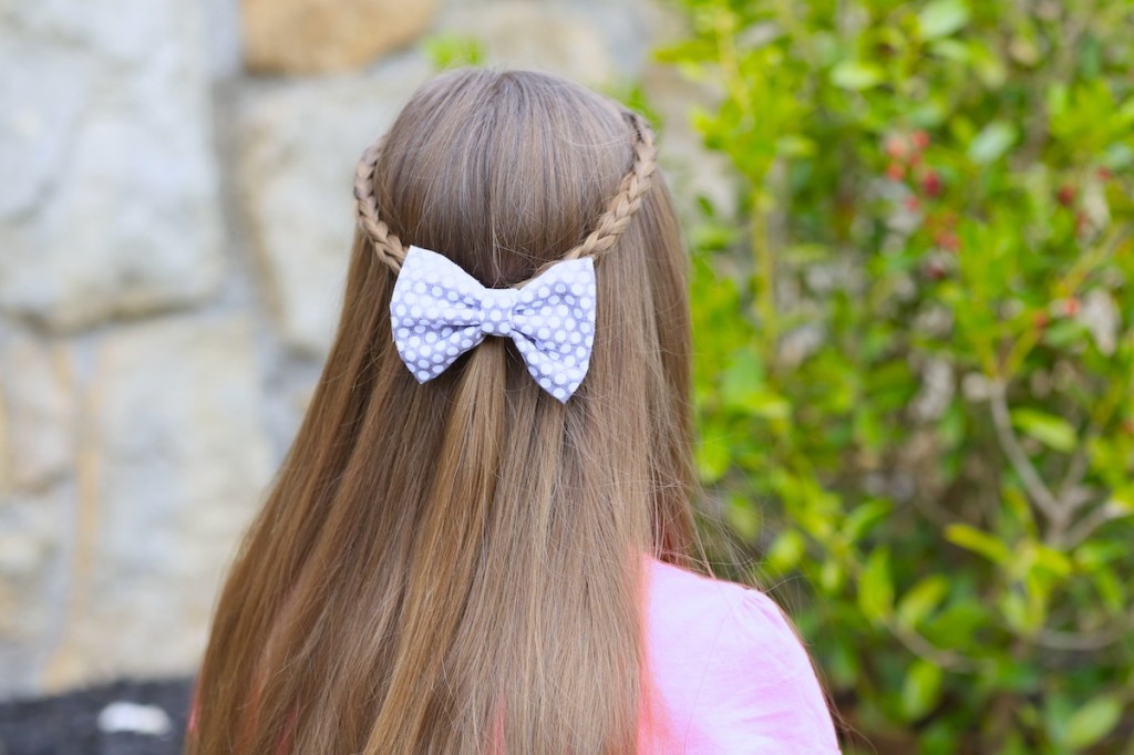 Young girl outside wearing pink shirt modeling 3D Split Braid