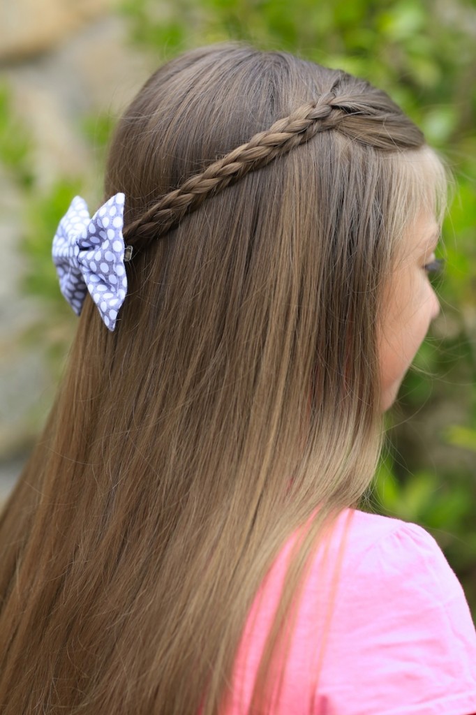 Young girl outside wearing pink shirt modeling 3D Split Braid