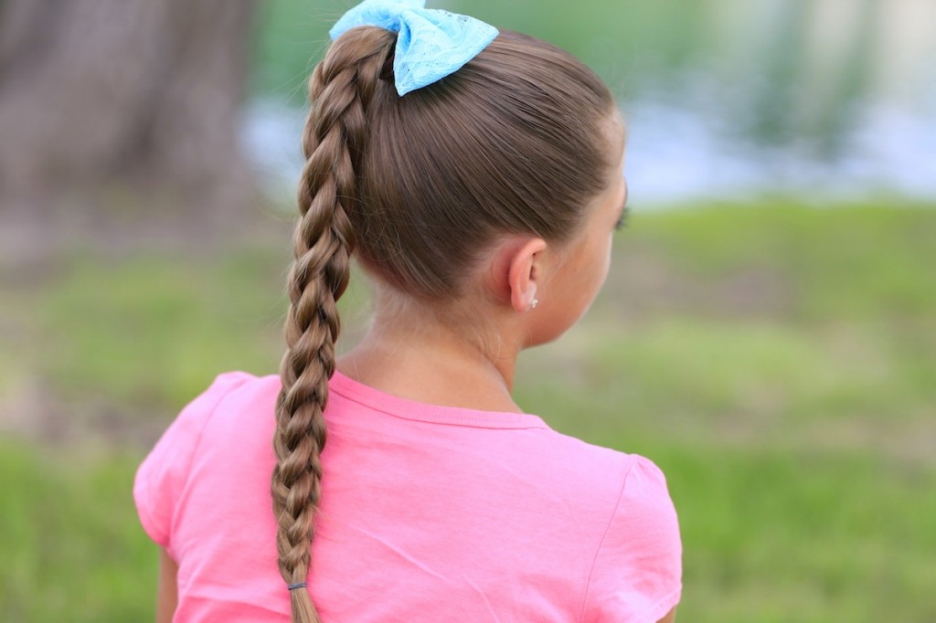 Little girl outside wearing a pink shirt modeling 3D Split Braid