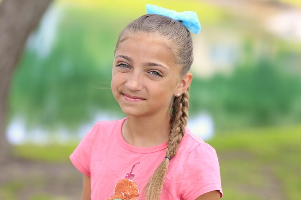 Little girl outside wearing a pink shirt modeling 3D Split Braid