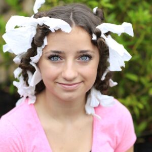 Young girl outside with tissue wrapped in her hair