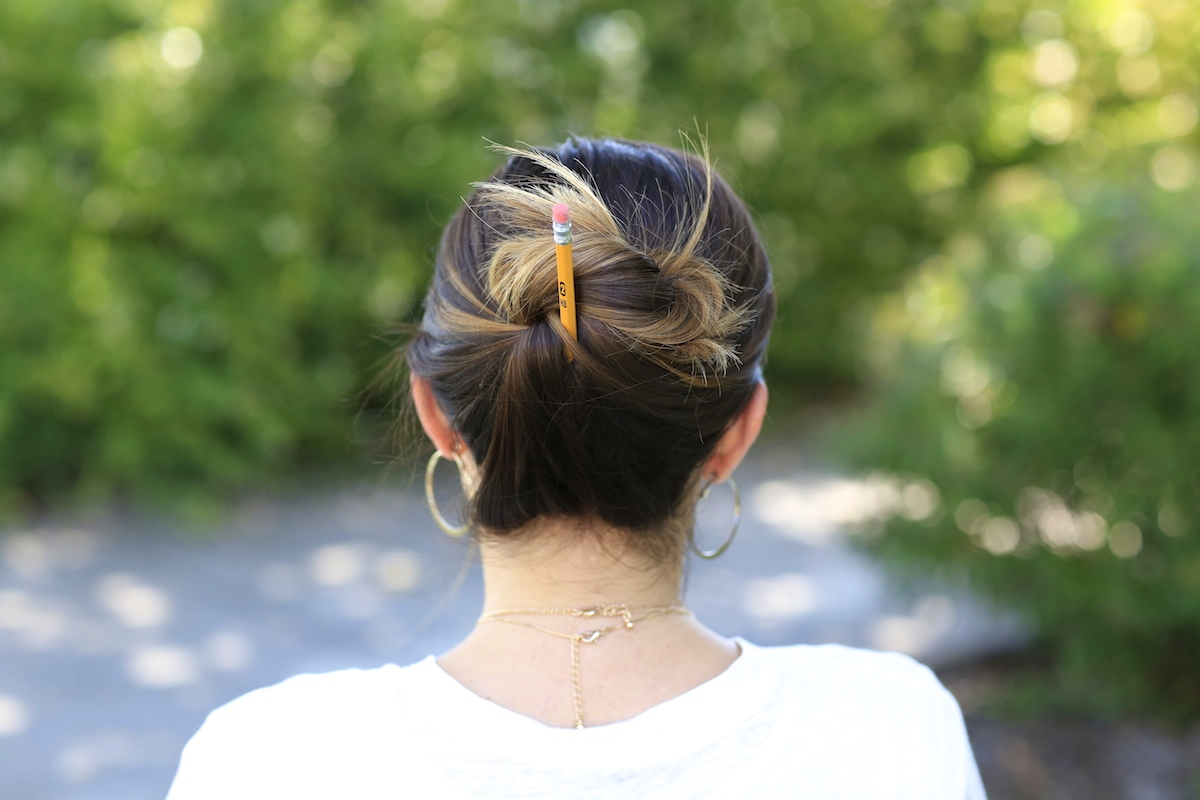 Woman outside modeling Pencil Messy Buns | Back-to-School Hairstyles