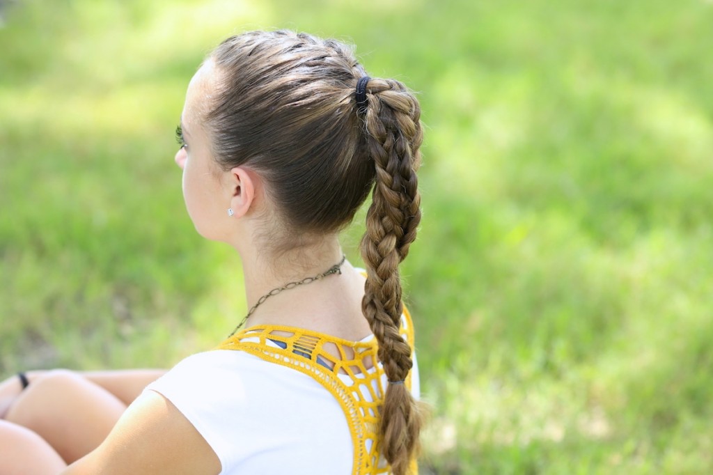 Young girl standing outside modeling The Run Braid Combo | Hairstyles for Sports