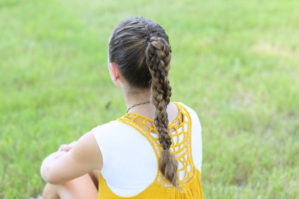 Young girl standing outside modeling The Run Braid Combo | Hairstyles for Sports