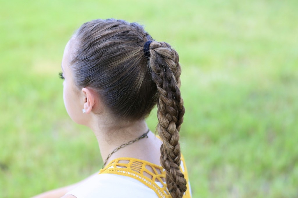 Young girl standing outside modeling The Run Braid Combo | Hairstyles for Sports