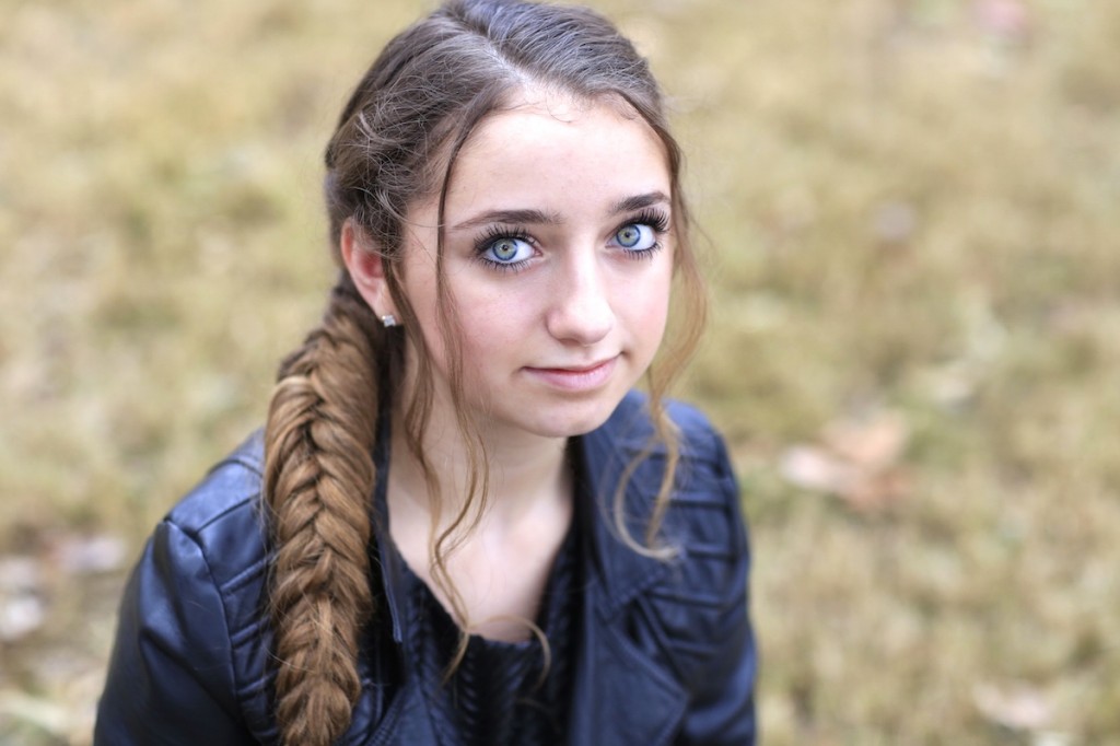 Girl outside wearing a back jacket modeling Katniss' Mockingjay Braid | Hunger Games Hairstyles