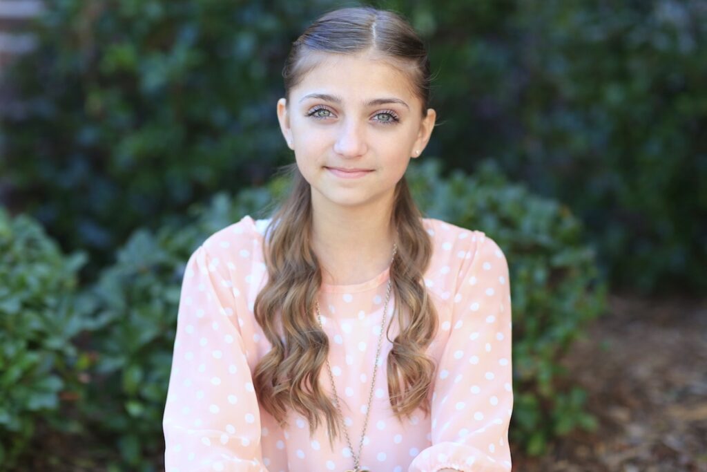 Young girl standing outside modeling Mermaid Heart Braid | Cute Valentine's Day Hairstyles