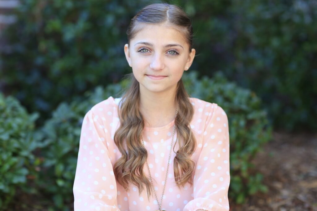 Young girl standing outside modeling Mermaid Heart Braid | Cute Valentine's Day Hairstyles