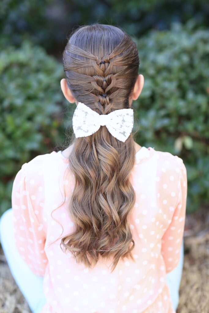 Young girl standing outside modeling Mermaid Heart Braid | Cute Valentine's Day Hairstyles (Back)