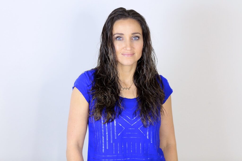 Portrait of woman with the blue shirt standing in front of a white background