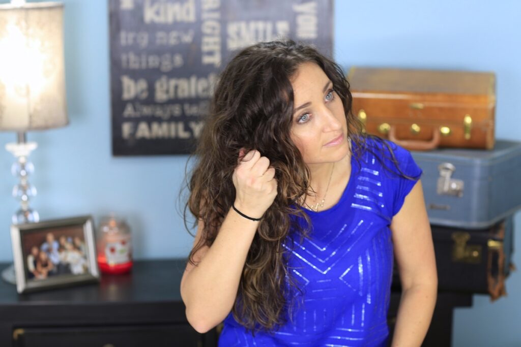 Woman styling her hair to create diffused curl