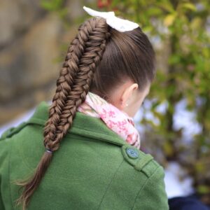 Young girl outside in a winter coat modeling Twisted Edge Fishtail Combo | Braid and Updo