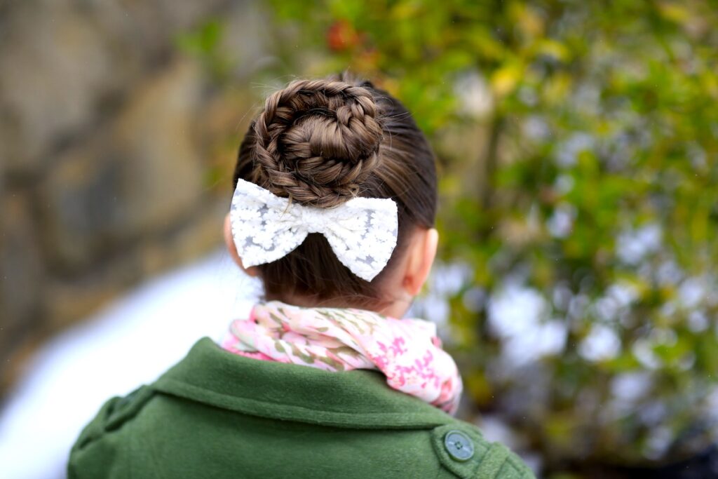 Young girl outside in a winter coat modeling Twisted Edge Fishtail Combo | Braid and Updo