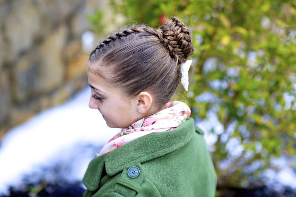 Young girl outside in a winter coat modeling Twisted Edge Fishtail Combo | Braid and Updo