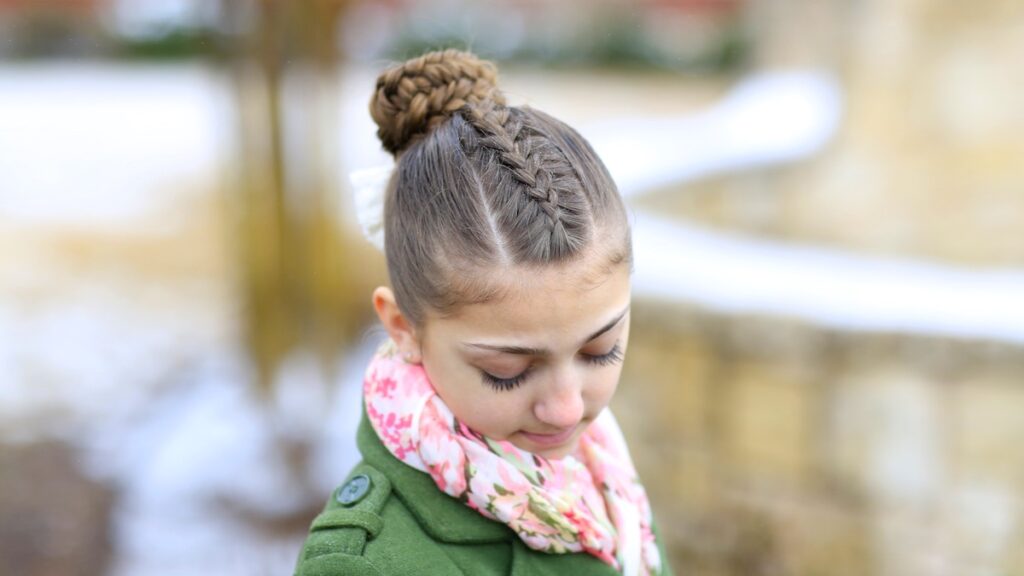 Young girl outside in a winter coat modeling Twisted Edge Fishtail Combo | Braid and Updo