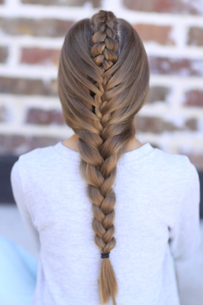 Young girl standing outside modeling Peek-a-Boo Tuxedo Braid