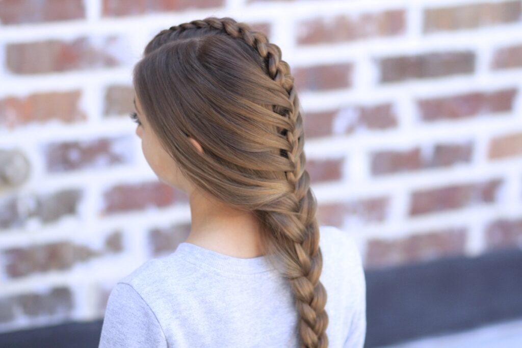 Young girl standing outside modeling Peek-a-Boo Tuxedo Braid