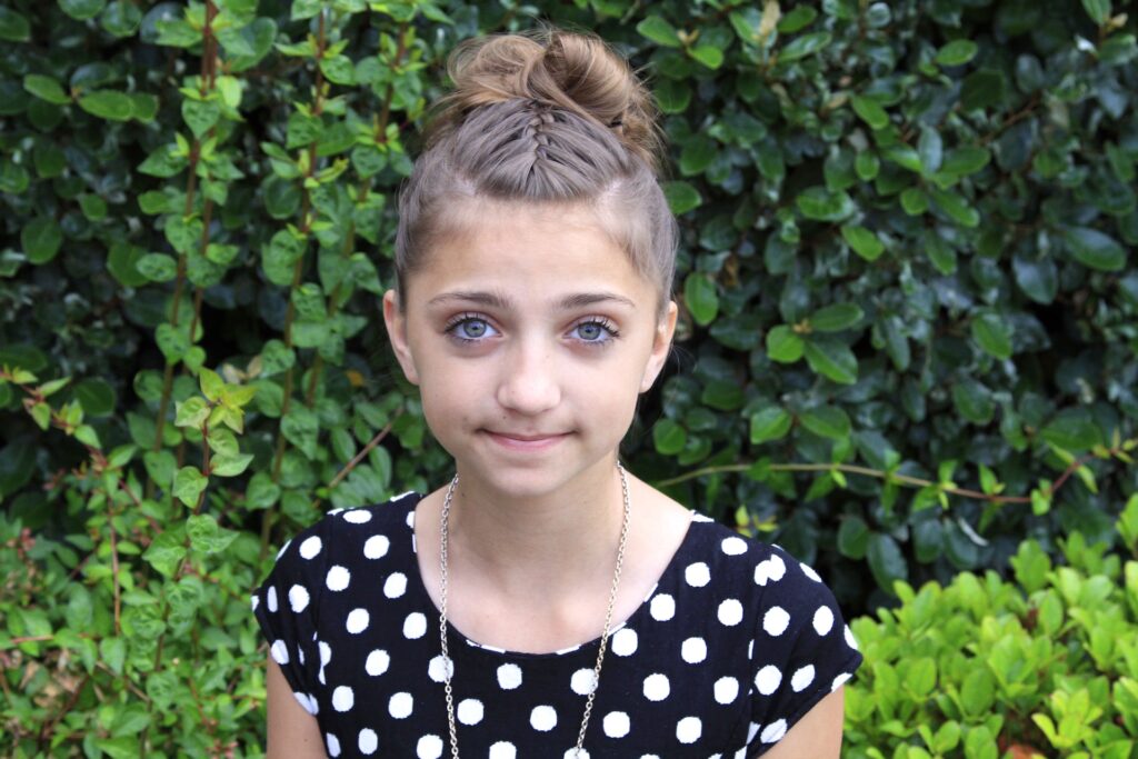 Young girl outside modeling Double-French Messy Bun Updo