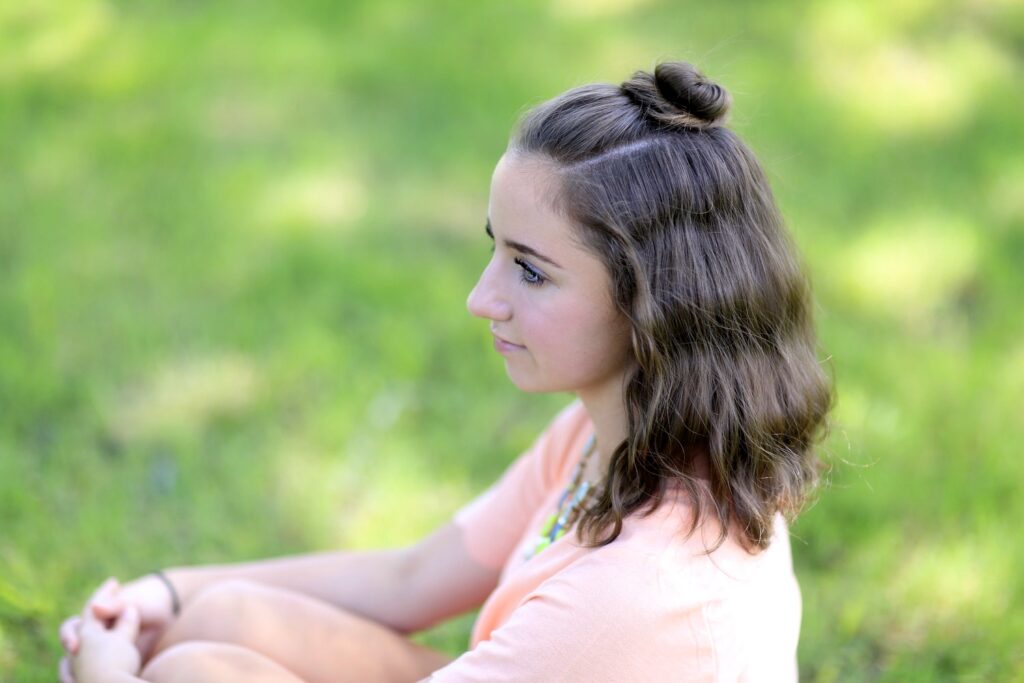 Young girl standing outside modeling Half Up Bun