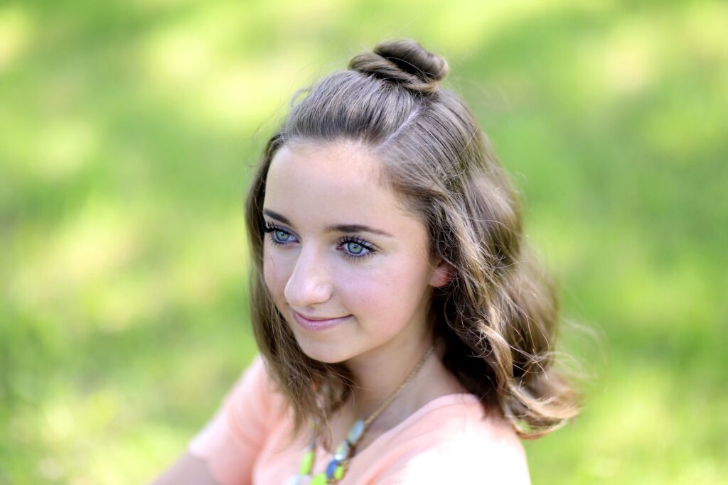 Young girl standing outside modeling Half Up Bun