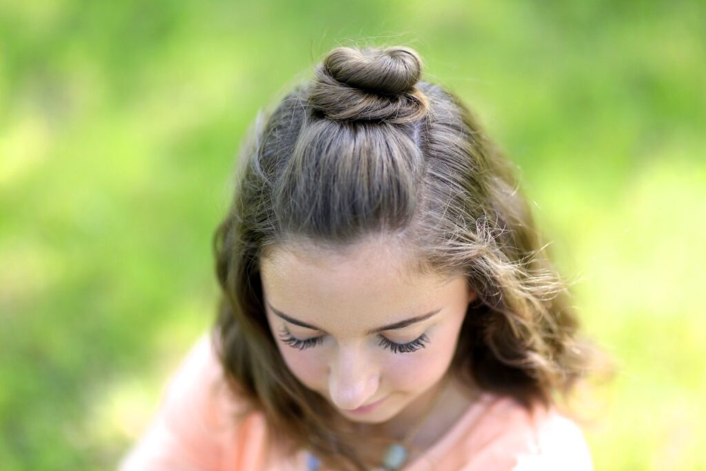 Young girl standing outside modeling Half Up Bun