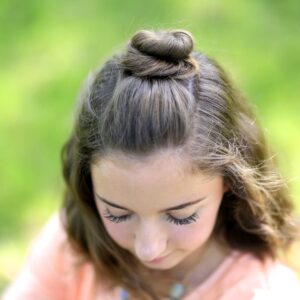 Young girl standing outside modeling Half Up Bun